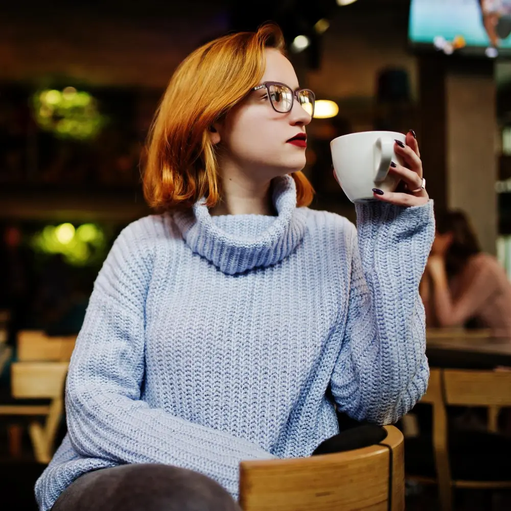 woman drinking her coffee at a cafe