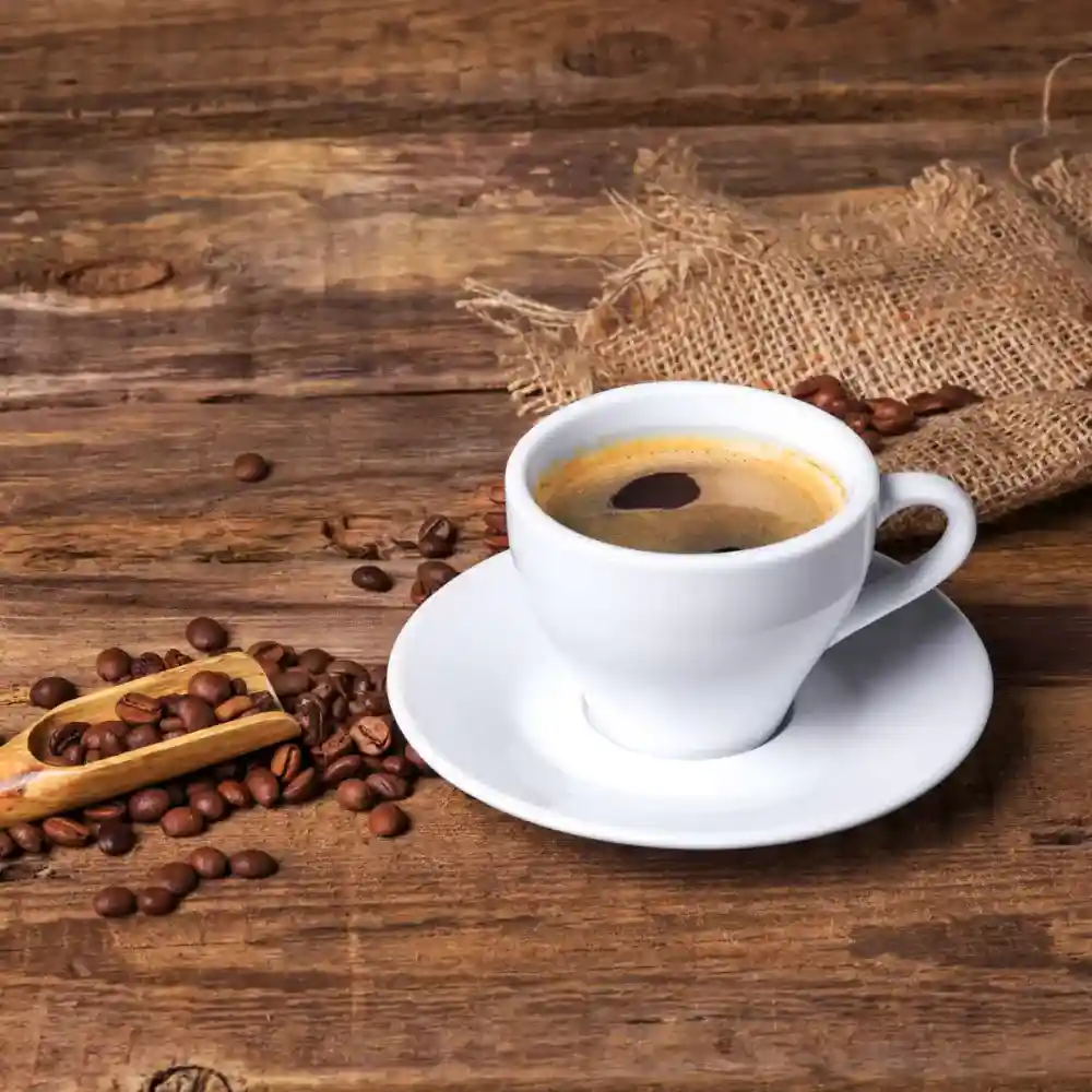 a white mug with black coffee on a wooden table