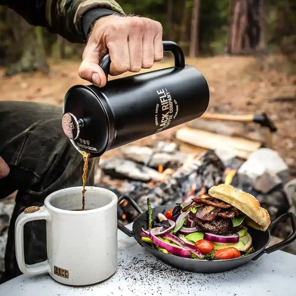 soldier brewing coffee on a camp site