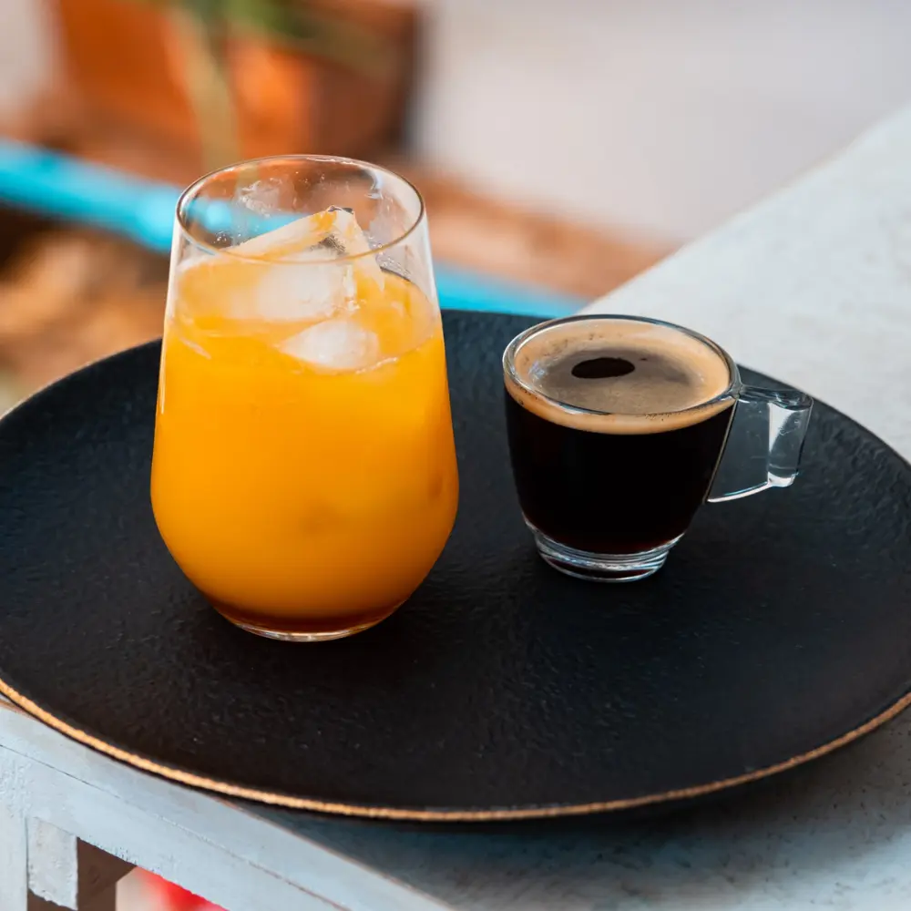 orange juice and black coffee on a tray