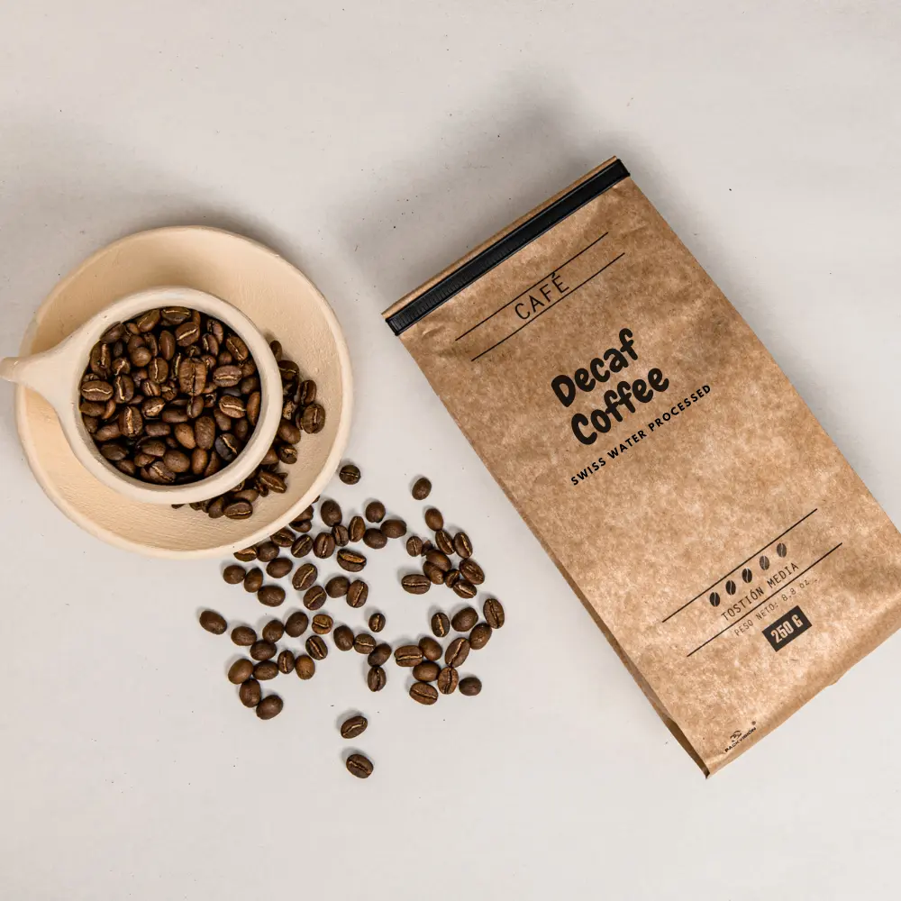 a paper bag of coffee next to a cup of coffee beans