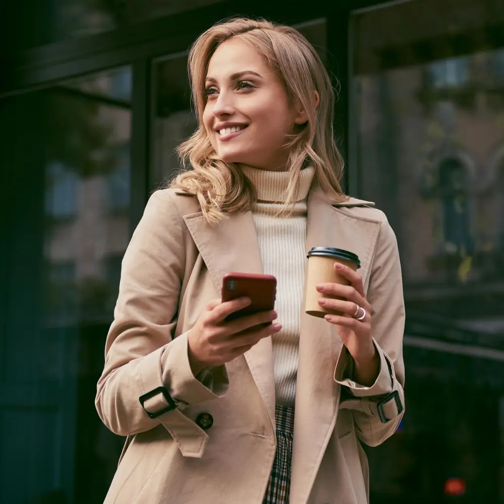 a woman on the go enjoying her coffee and using her mobile