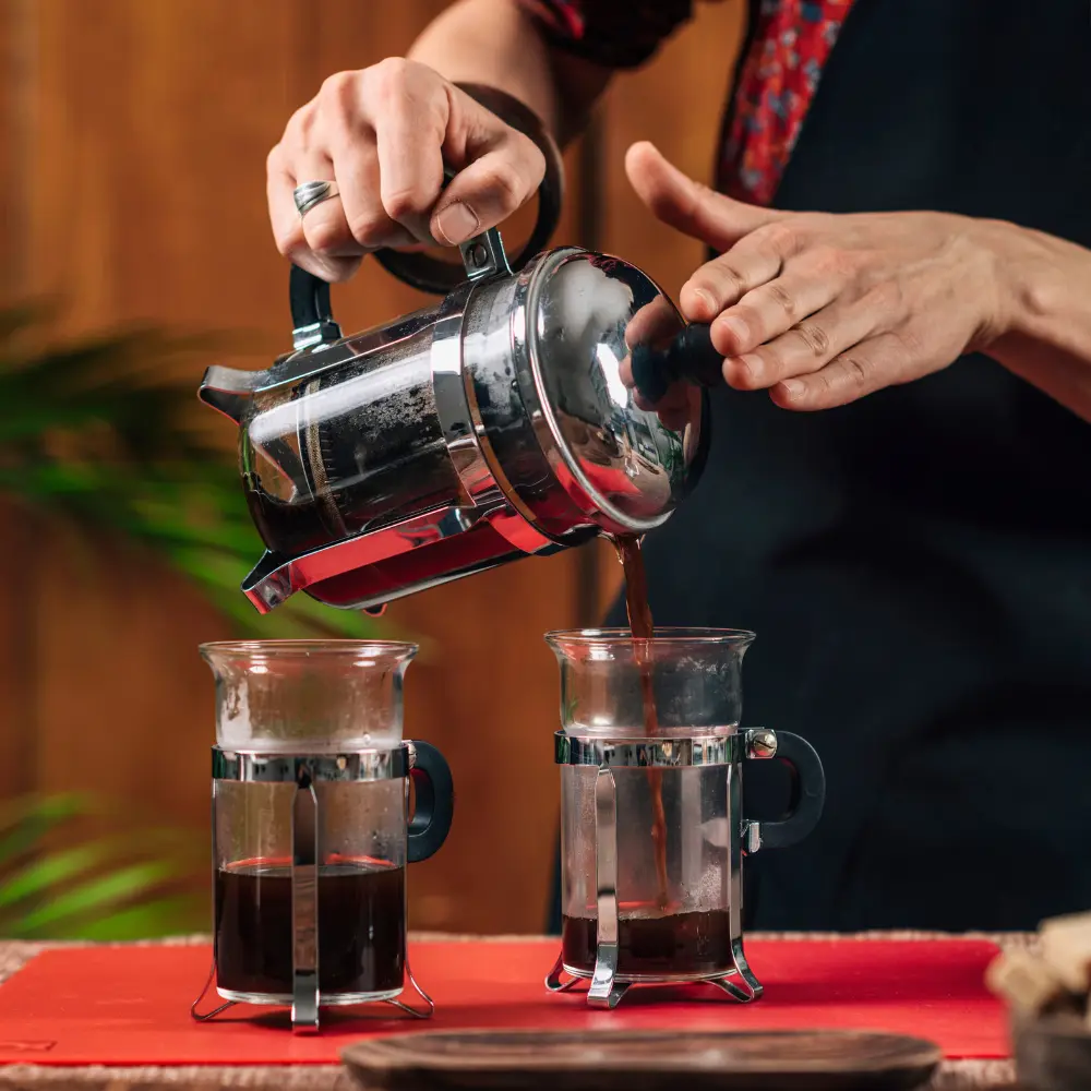 barista brewing french press coffee