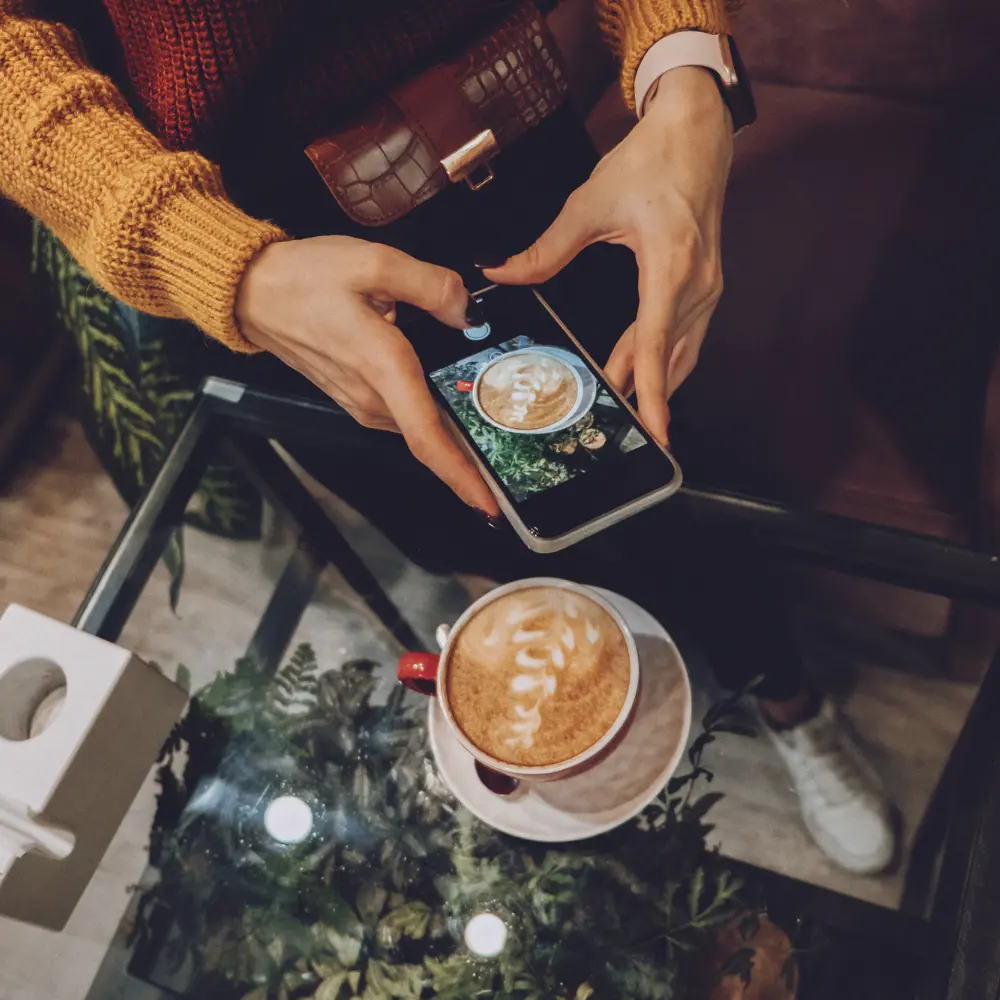 woman taking a photo of her latte with her mobile