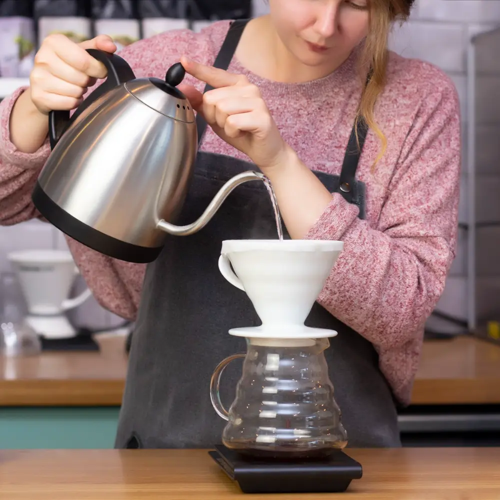 barista brewing with the hario v60 coffee maker