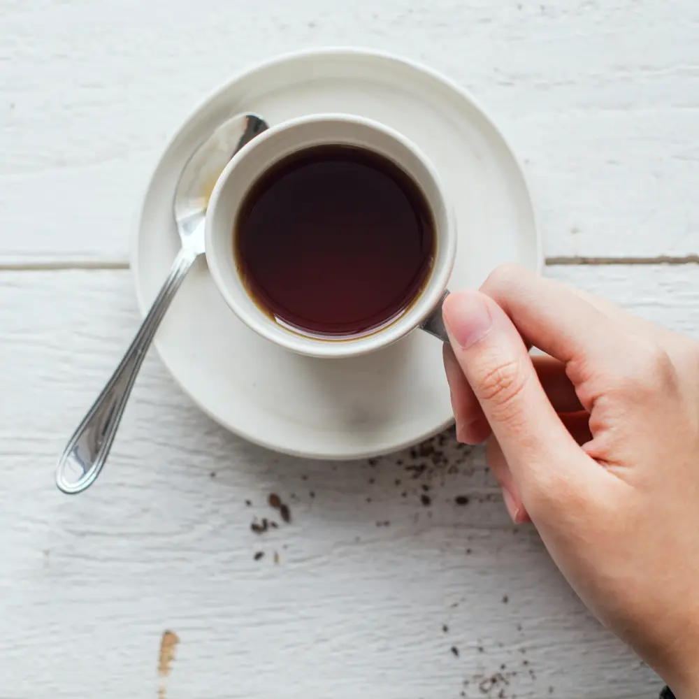 person holding a black cup of coffee