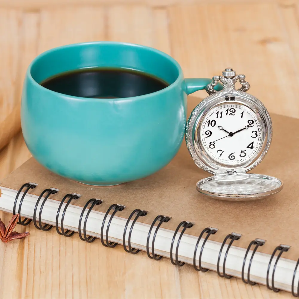 a green teal mug of coffee and a timer waiting to drink before a blood test