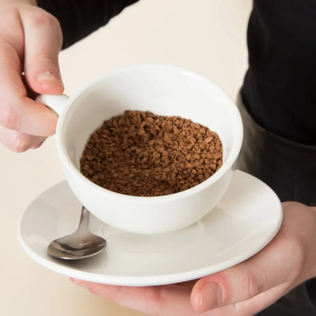 person holding a mug filled with instant coffee