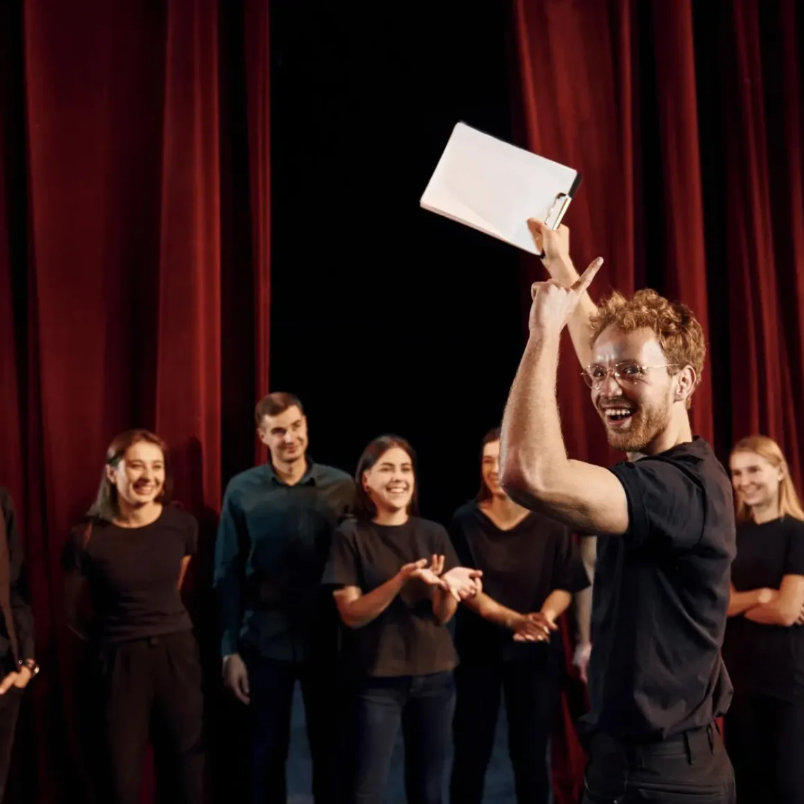 a person holding a clipboard and a group of people clapping after hearing a coffee pun