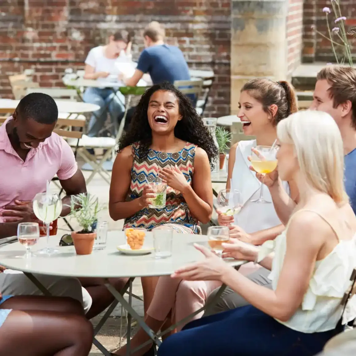 a group of people laughing at a table after saying jokes about coffee