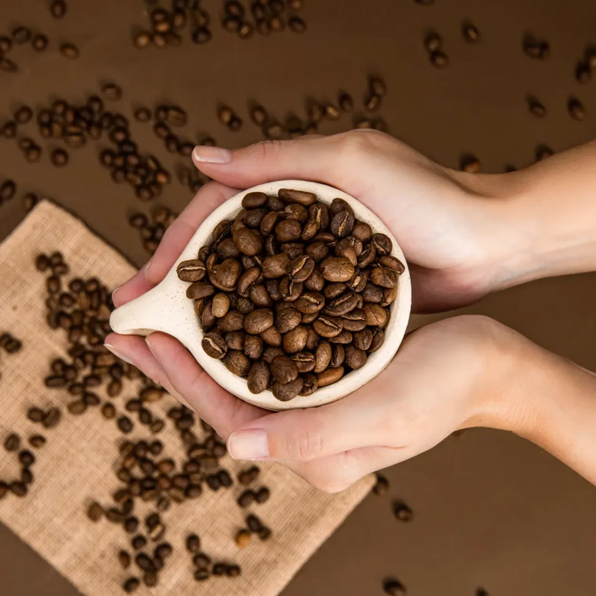 a person holding a cup of coffee beans