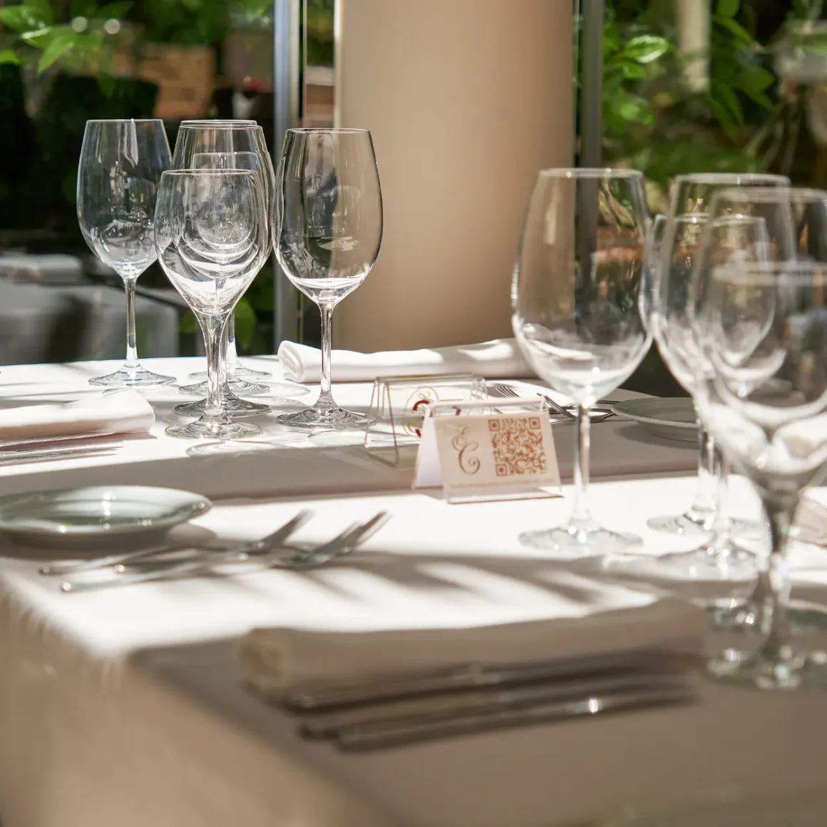 a table with wine glasses and napkins