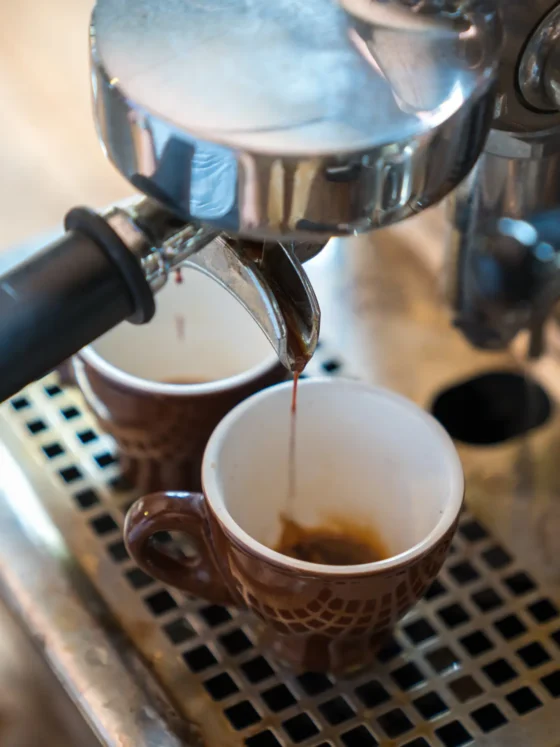 a coffee machine pouring coffee into two cups