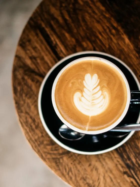 a cup of coffee with a leaf design in the foam