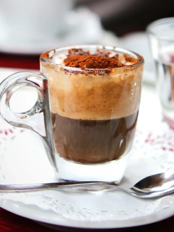 a glass cup of coffee with a spoon