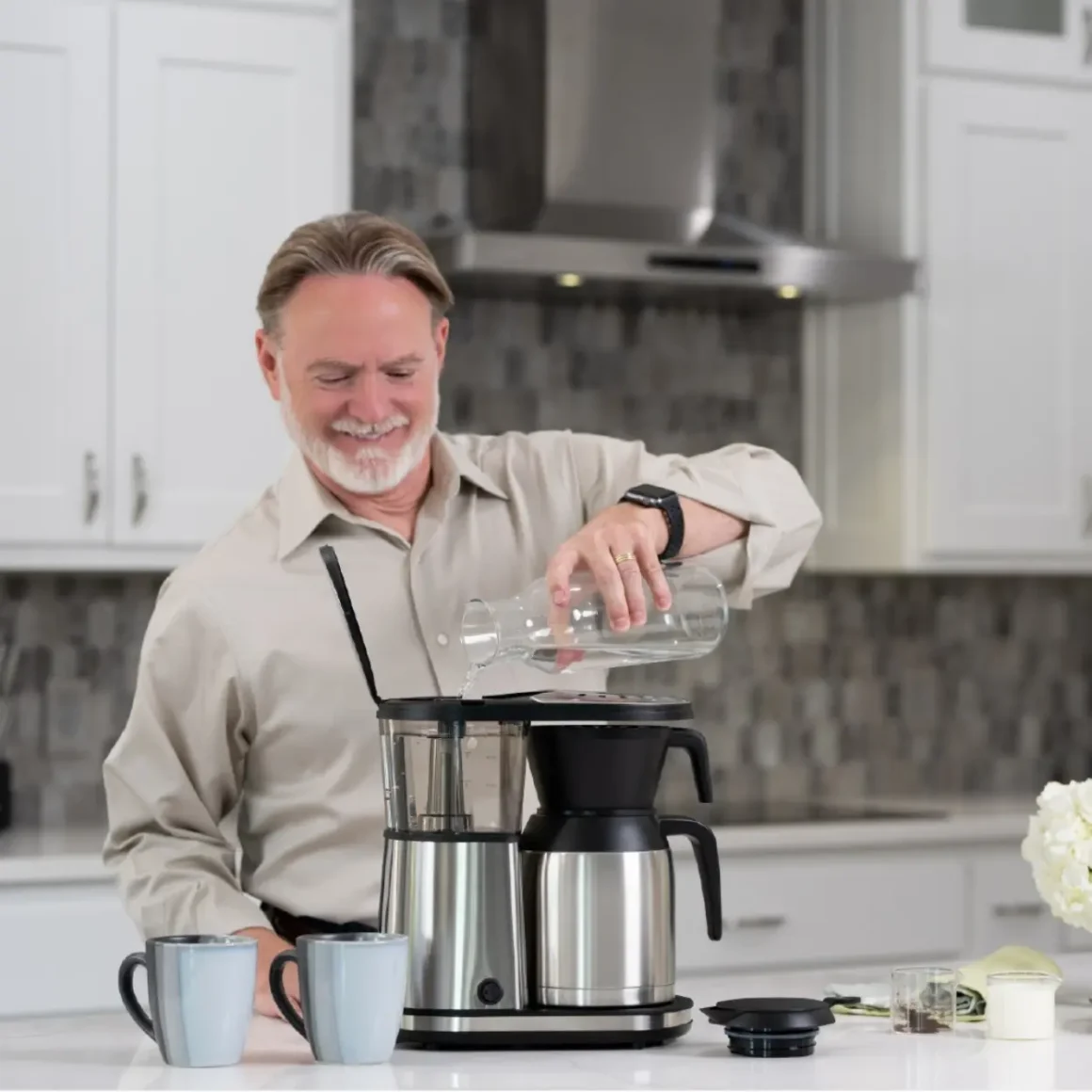 a person pouring water into bonavita 8 cup coffee maker
