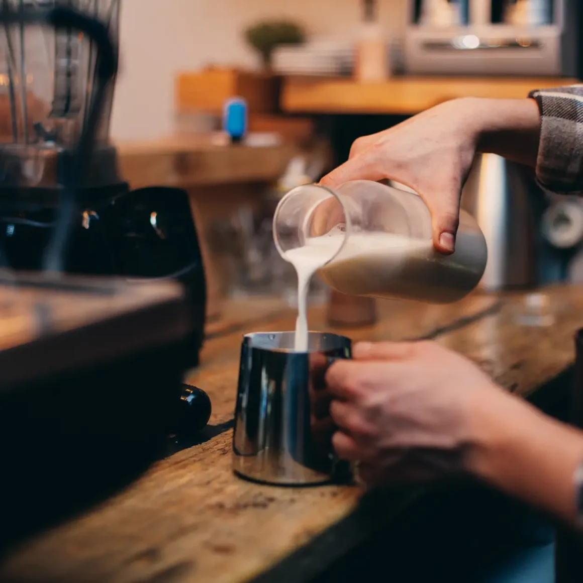 a person pouring milk into a cup