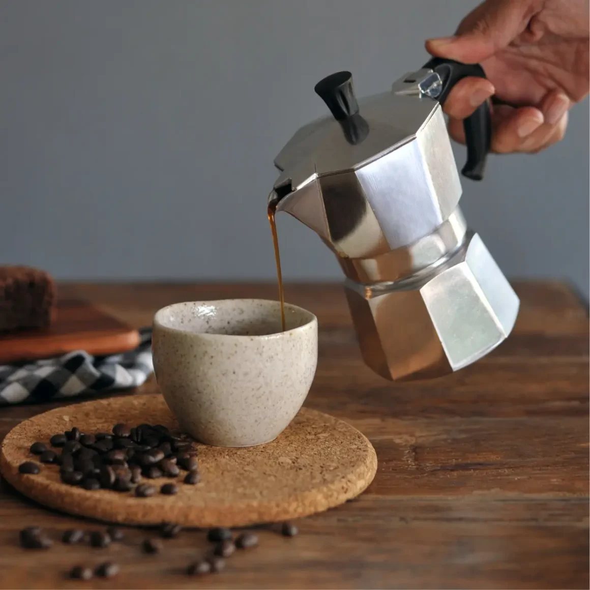 a person pouring cafe au lait into a cup
