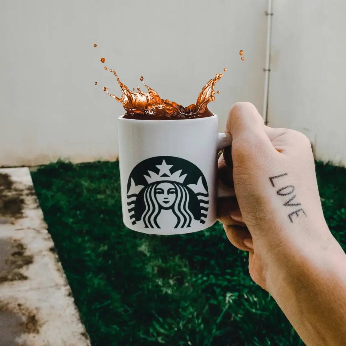 a hand holding a coffee cup