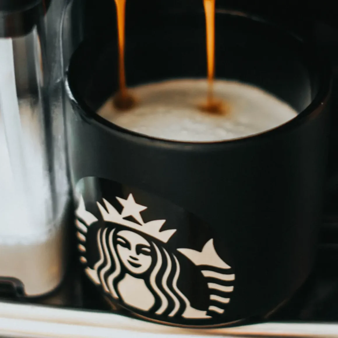 a coffee maker pouring coffee into a cup