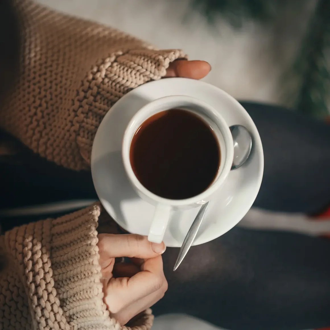 a person holding a cup of drip coffee