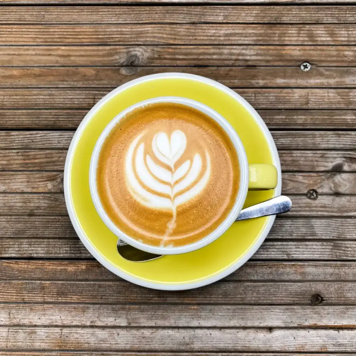 a cup of coffee with a leaf design in the foam