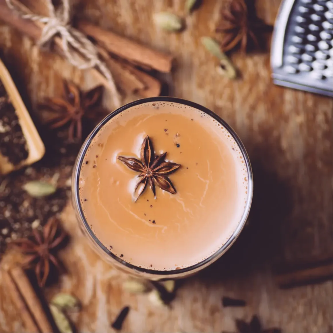a glass of chai latte with anise and spices