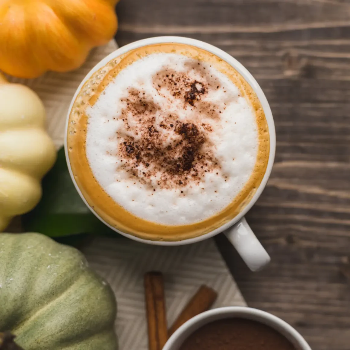 a cup of coconut pumpkin latte with a foamy froth and a pumpkin