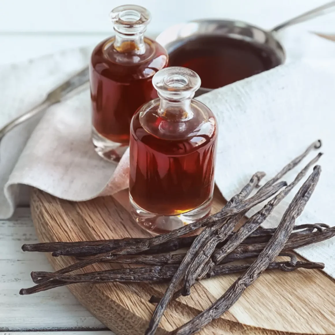 a group of bottles of coffee syrups next to vanilla sticks