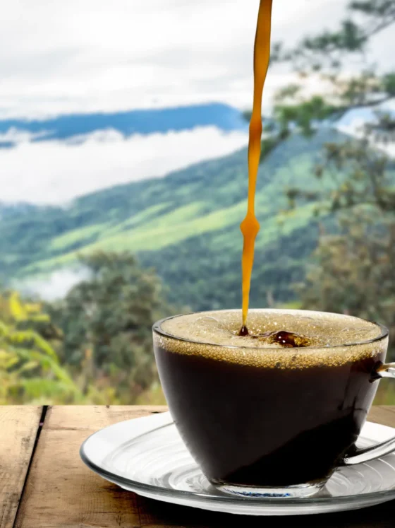 a cup of coffee with a coffee being poured into it
