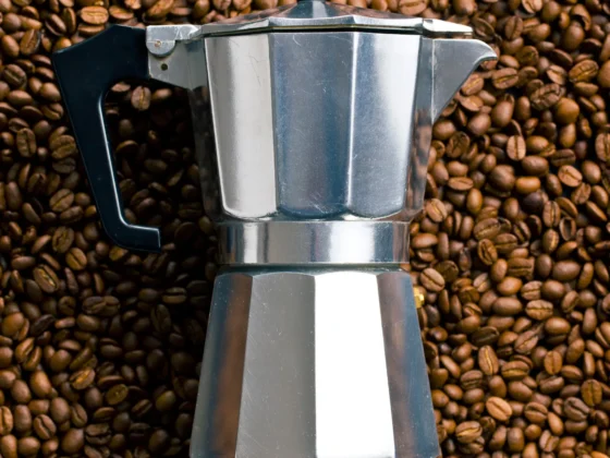 a coffee maker on a pile of coffee beans