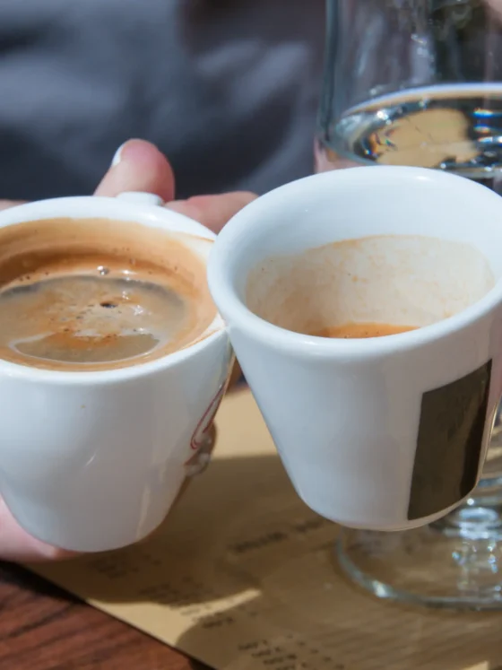 a person holding cups of coffee