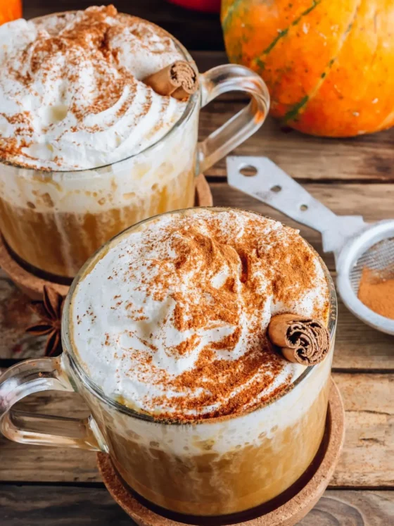 a two mugs of coffee with whipped cream and cinnamon