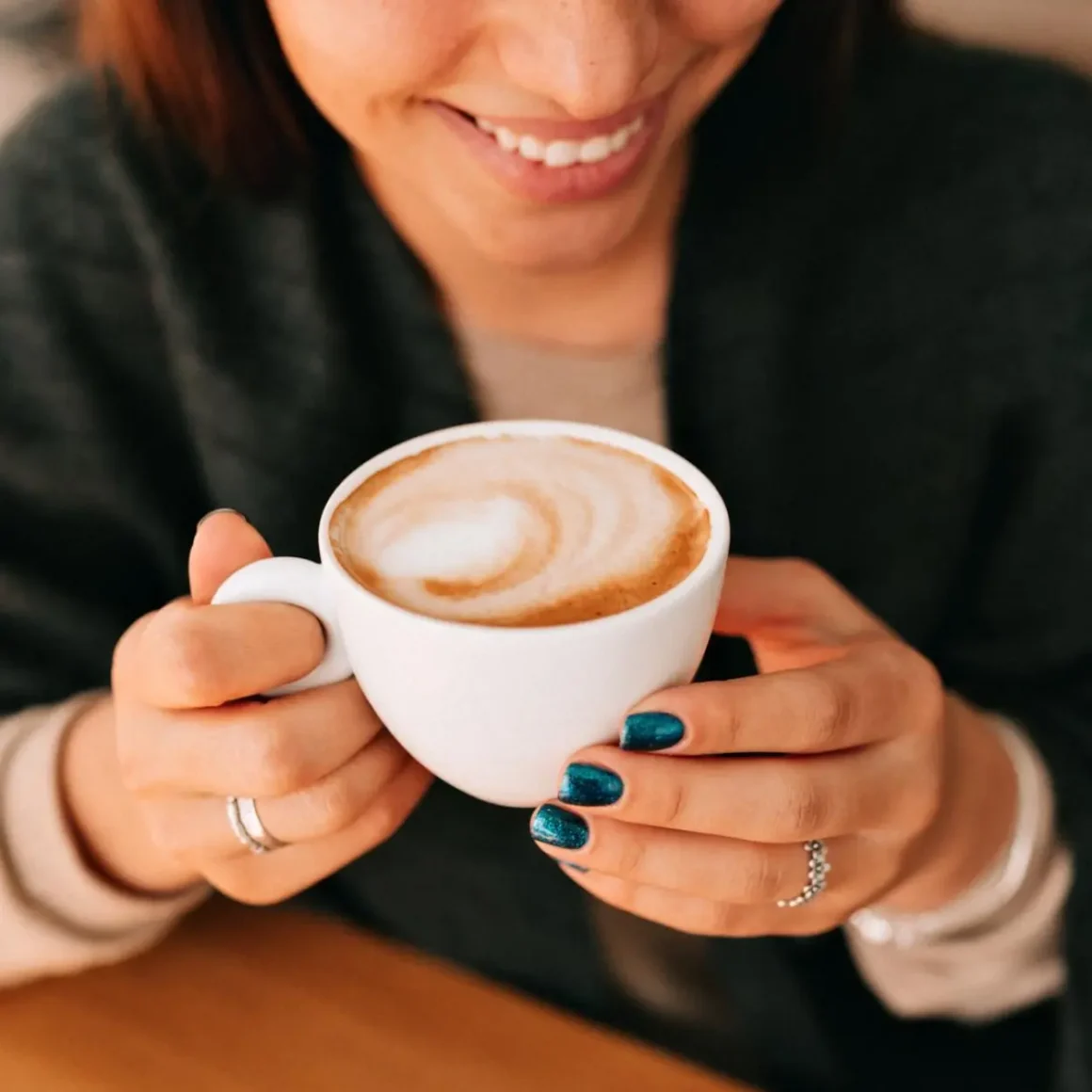 a person holding a cup of cappuccino