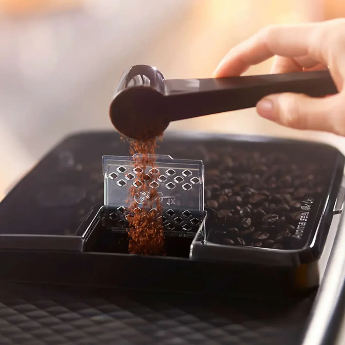 a person pouring coffee into a Philips 4300 coffee machine