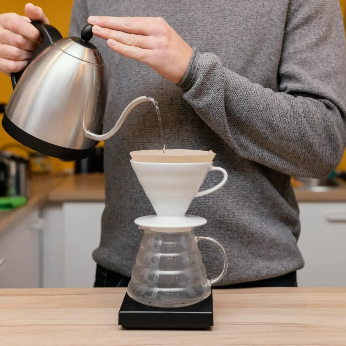 a person pouring water into a dripper