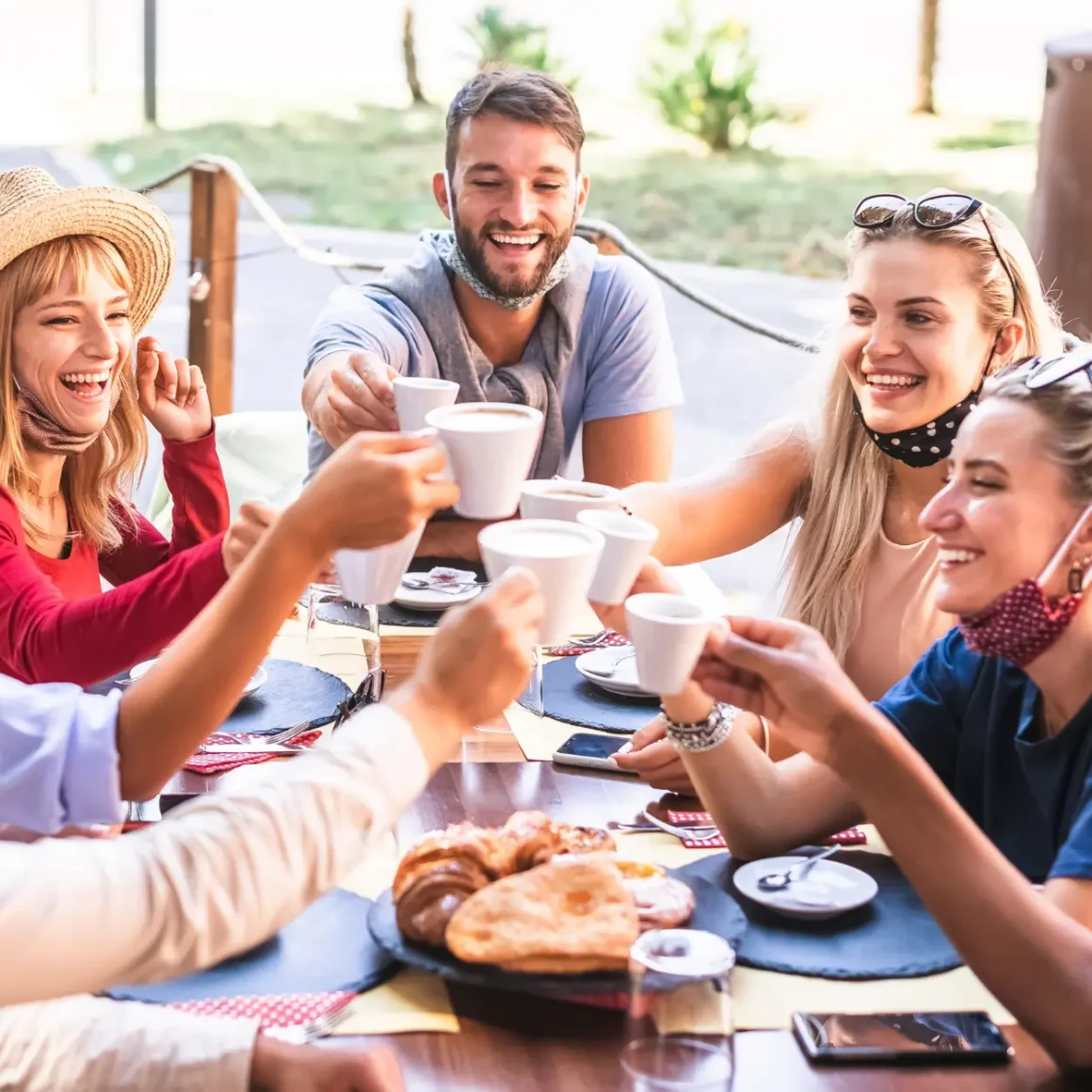 a group of people sitting at a table with cups of coffee