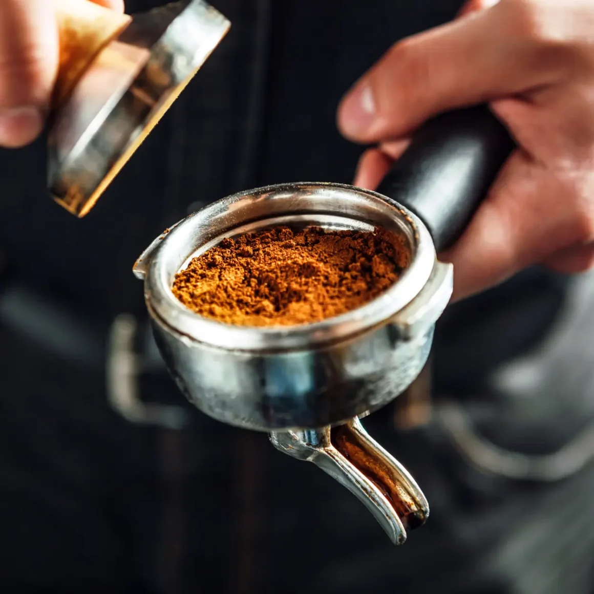 a barista holding a portafilter preparing a Ristretto shot