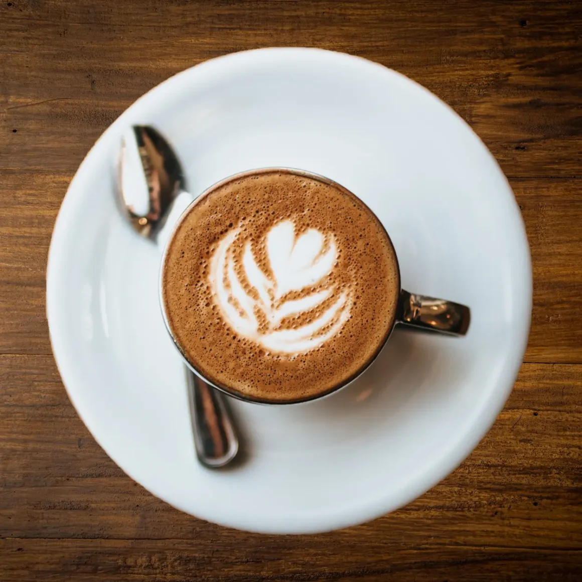 a cup of coffee with a design on the foam