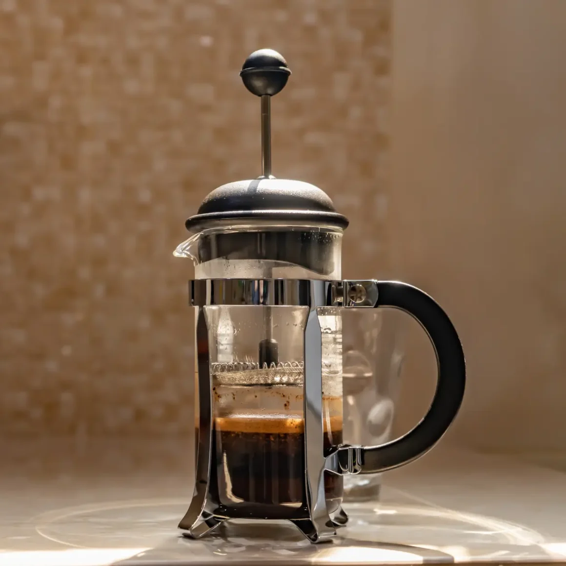 a french press with a handle and coffee in it
