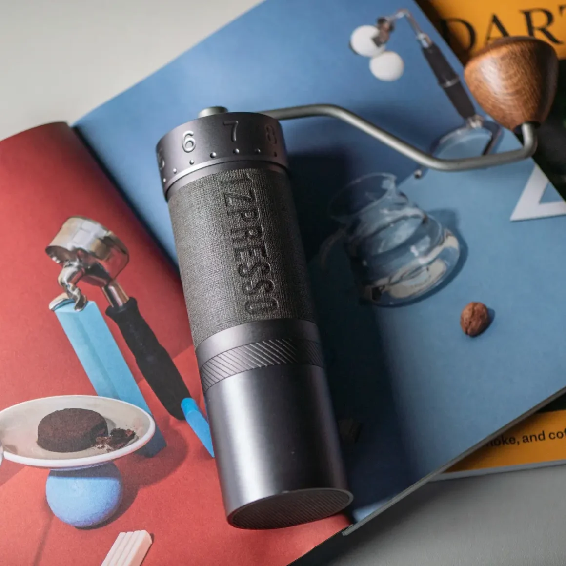 1zpresso k-ultra manual coffee grinder on a book