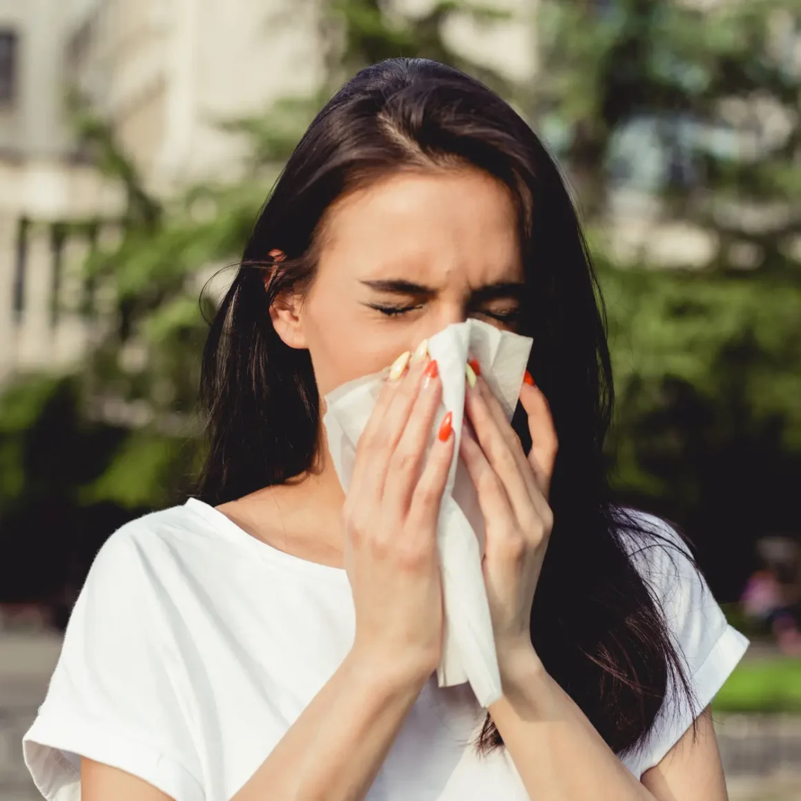 a woman blowing her nose with a tissue