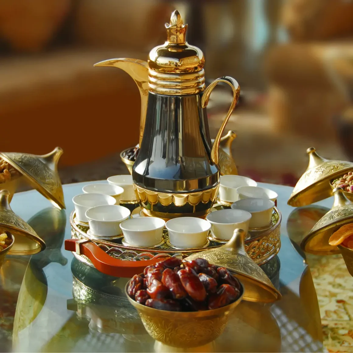 a gold arabic coffee pot and cups on a table