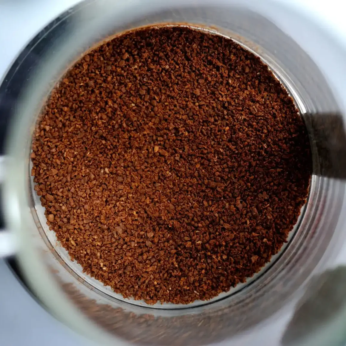 a glass jar filled with ground coffee