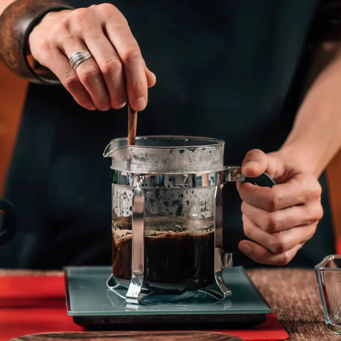 barista brewing coffee in a glass container