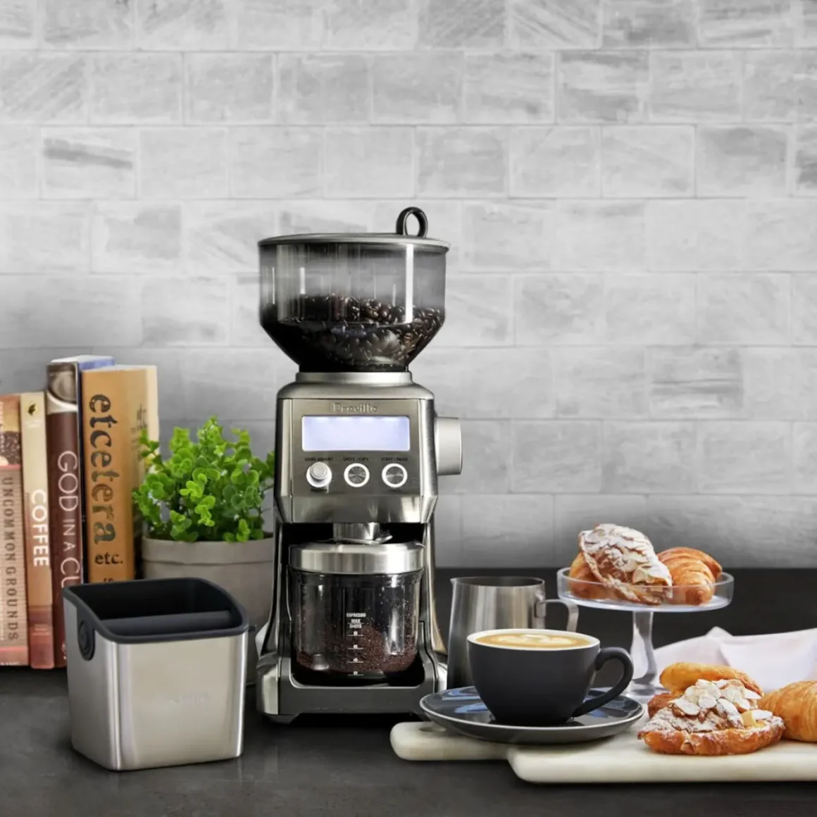 a breville smart pro coffee burr grinder and pastries on a table