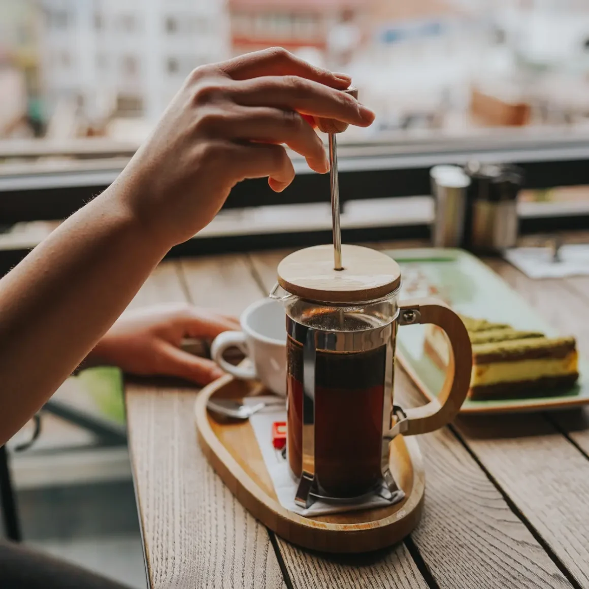 barista brewing medium roast coffee in a french press