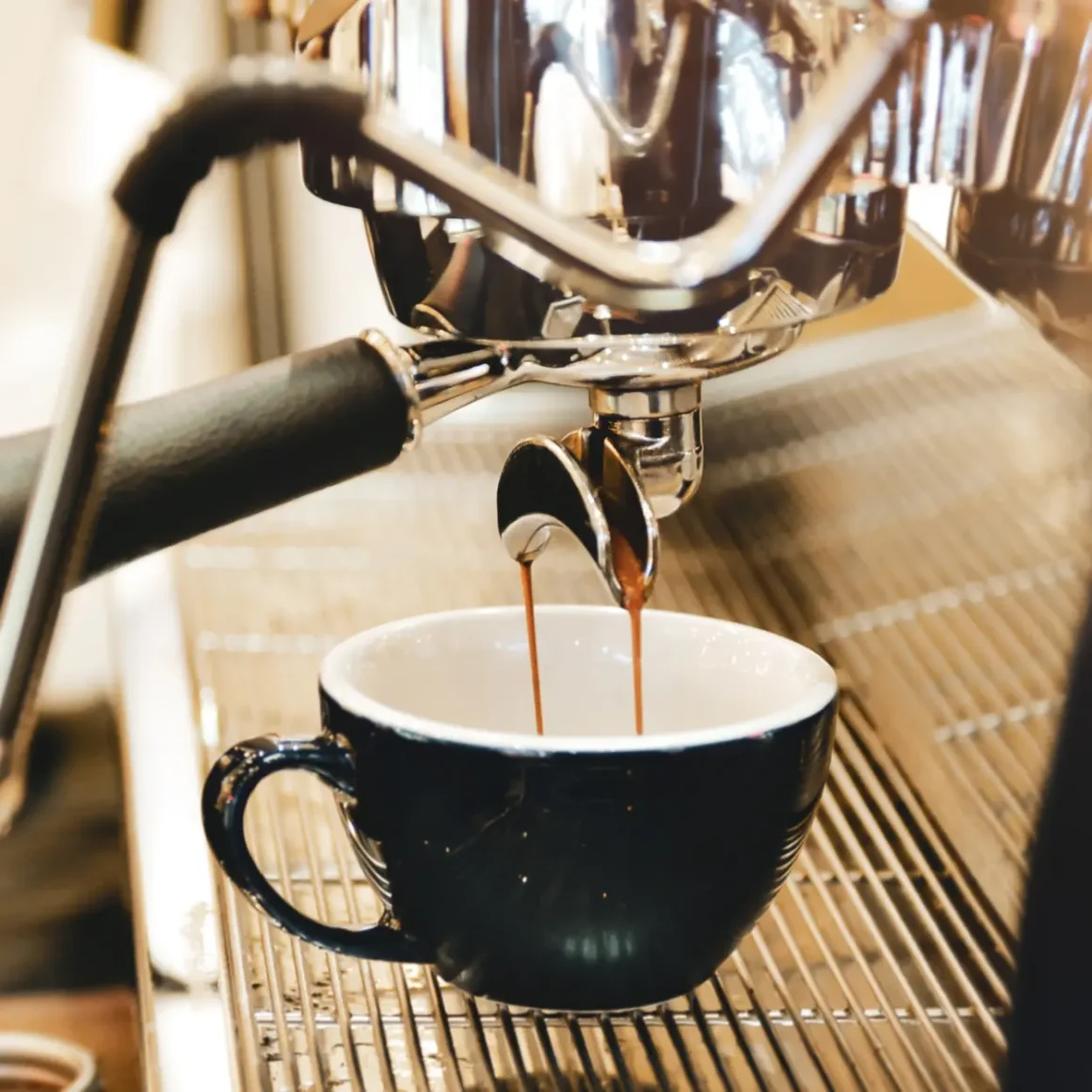 an espresso machine pouring coffee into a black cup