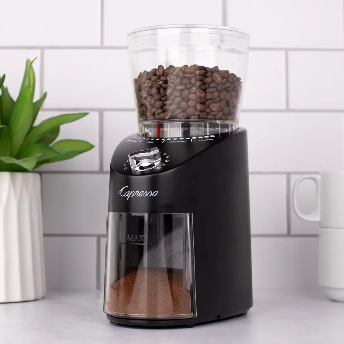 a capresso infinity coffee grinder with beans in it