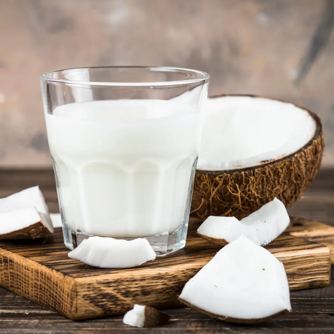 a glass of coconut milk and a coconut on a counter